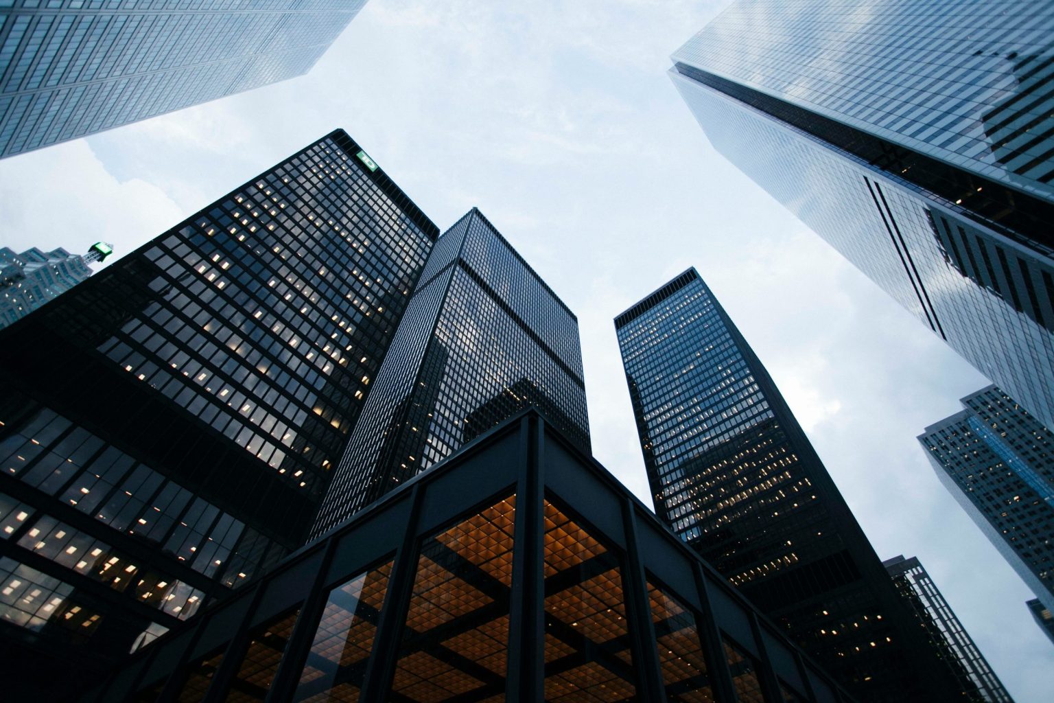Office towers seen from below at dusk, windows lit